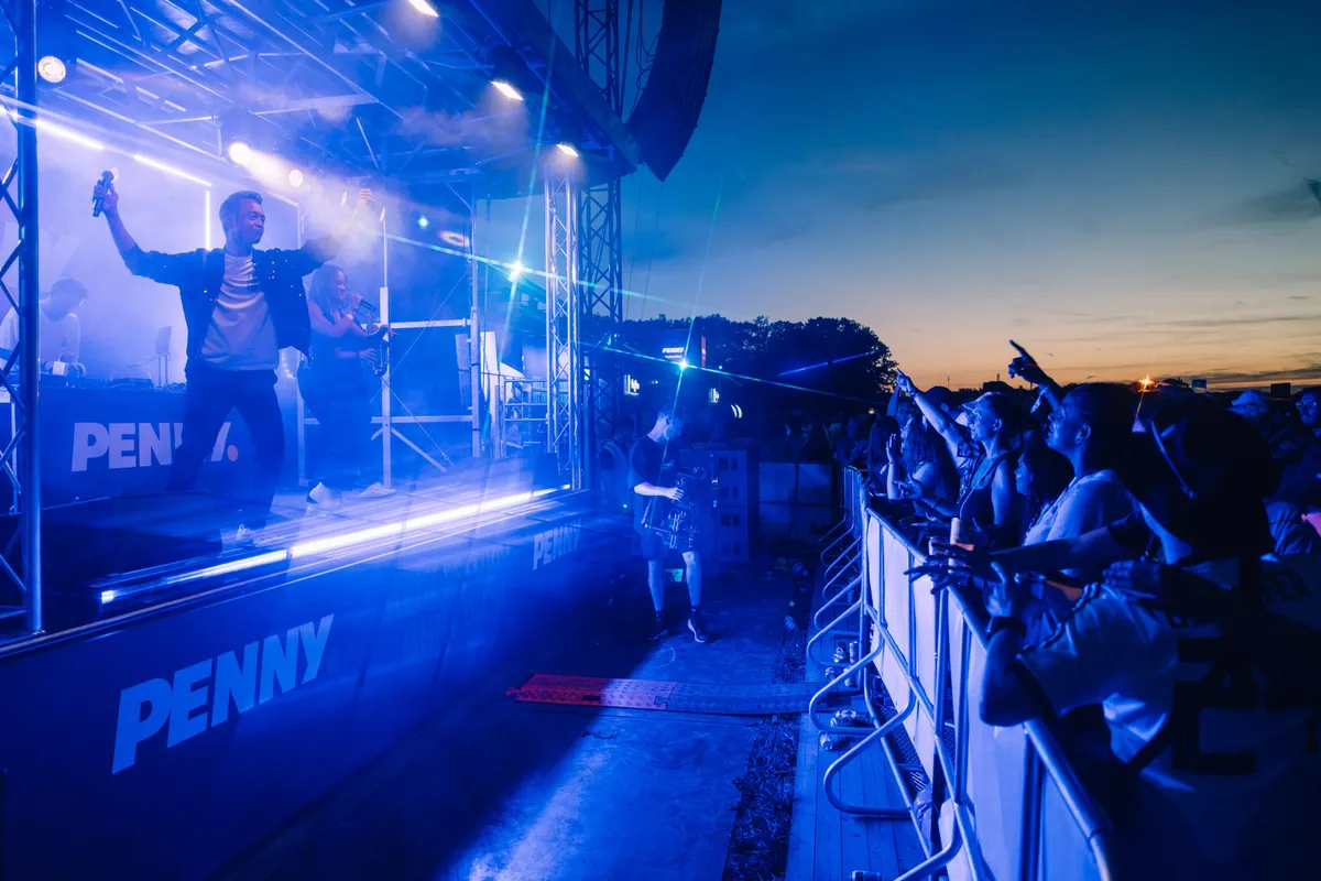 Deejay Plus beim Festival mit glücklichen Besuchern und festlicher Stimmung.